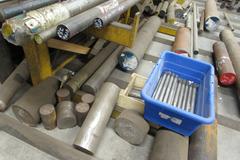 Raw Material Contents of Bar Stock Area Including (4) Racks, Material On Floor up to 17" x 98" Round Steel Bar, Aluminum, and More.  THOUSANDS OF POUNDS OF STEEL!!