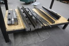 Amada Press Brake Dies, Ram Clamps and Lower Die Holders on Steel Rack